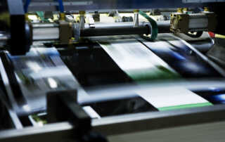 An image of a large flat-bed printer actively printing out new products